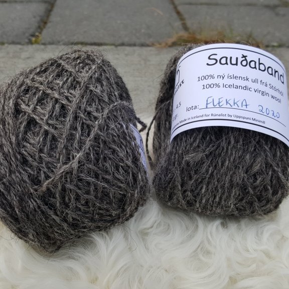 Sauðaband - Flekka - svarflekkótt
Sauðaband er unnið úr Ull af kindinni okkar, Flekku sem er svarflekkótt.  Bandið var spunið fyrir okkur í Uppspuna Smáspunaverksmiðju.  Bandið er tvinnað,  prjónastærð er 3 - 6,5 en ég nota mest 3,5 -4,5 (prjóna frekar laust),  50 grömm eru um 100m.